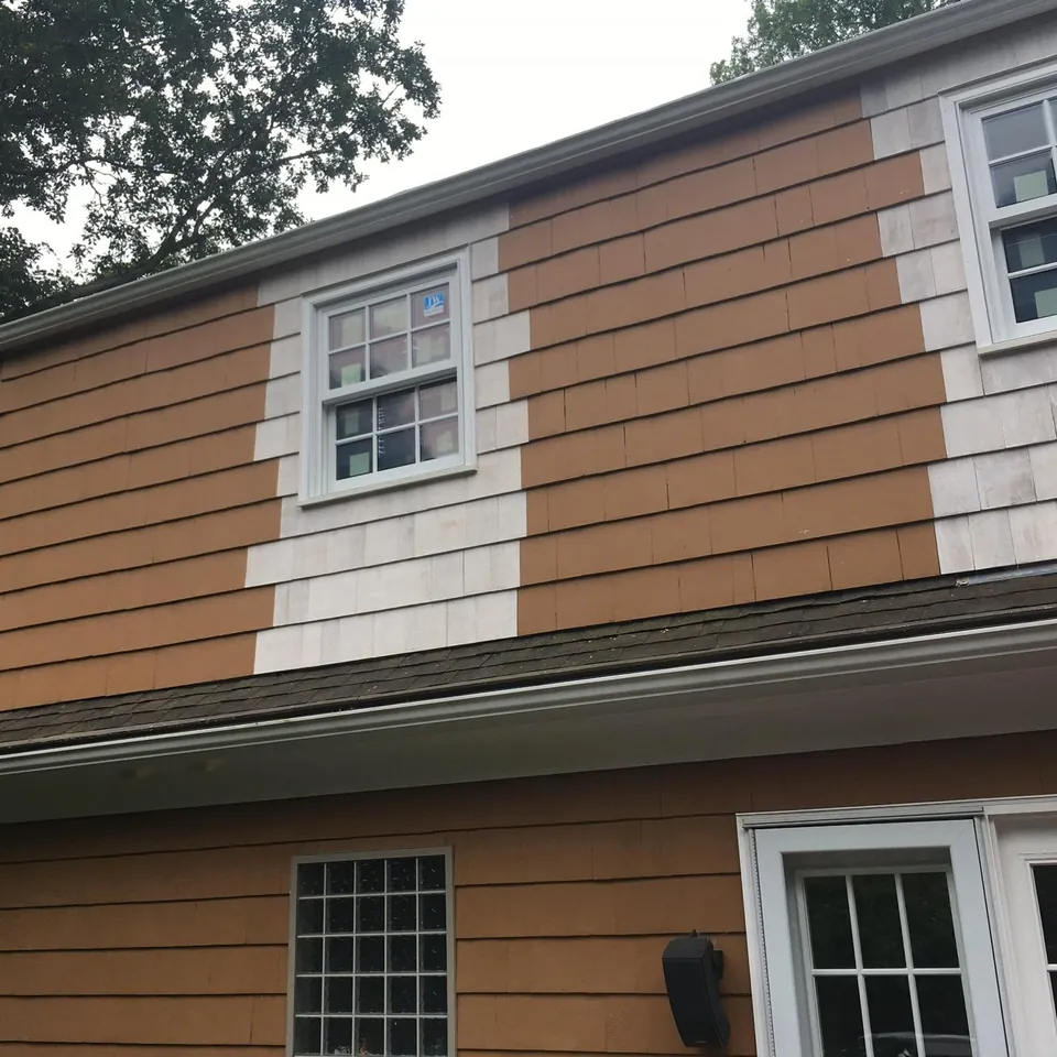 New double-hung window with white trim in a cedar-shingled gable above clapboard siding